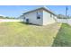 View of a large backyard with healthy grass, AC unit, and a white fence surrounding the property at 717 Robin Ct, Kissimmee, FL 34759