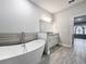 Bright bathroom with a soaking tub, granite countertops, and gray-tone accent tiles at 717 Robin Ct, Kissimmee, FL 34759