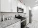 Updated kitchen features white cabinets, stainless steel appliances, and granite countertops at 717 Robin Ct, Kissimmee, FL 34759