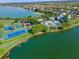 Aerial view of the community including a pool, playground, tennis court, basketball court, and lake at 724 Barefoot Bay Loop, Groveland, FL 34736