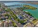 This aerial view shows homes lining streets with mature trees near a lake, highlighting the neighborhood's charm at 724 Barefoot Bay Loop, Groveland, FL 34736