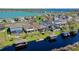 Aerial view of waterfront homes with docks and boat lifts on a serene lake at 724 Barefoot Bay Loop, Groveland, FL 34736