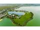 Beautiful aerial view of a Primary-planned community featuring a large lake, clubhouse, pool, sports courts, and green spaces at 724 Barefoot Bay Loop, Groveland, FL 34736