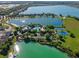 Aerial view showing lake with fountain, community pool, sports courts, lush landscape, and neighborhood at 724 Barefoot Bay Loop, Groveland, FL 34736