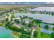 Aerial view featuring community amenities including a pool, playground, and tennis courts by a tranquil lake at 724 Barefoot Bay Loop, Groveland, FL 34736