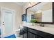 Well-lit bathroom with a spacious vanity, large mirror, and direct access to the outdoors at 724 Barefoot Bay Loop, Groveland, FL 34736