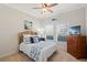 Cozy bedroom featuring a wicker headboard, beach-themed decor, and natural light from two windows at 724 Barefoot Bay Loop, Groveland, FL 34736