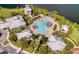 Aerial view of a community pool with waterslide, surrounded by lush landscaping and buildings near the lake at 724 Barefoot Bay Loop, Groveland, FL 34736