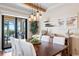 Dining room with dark wood table, stylish light fixture, and sliding glass doors leading to lanai at 724 Barefoot Bay Loop, Groveland, FL 34736