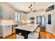 A bright kitchen features white cabinets, stainless steel appliances, a center island with seating, and hardwood floors at 724 Barefoot Bay Loop, Groveland, FL 34736