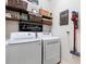 Well-organized laundry room featuring a modern washer, dryer, and decorative shelves and wall decor at 724 Barefoot Bay Loop, Groveland, FL 34736