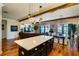 Open concept living room with island, wood beams, dining area, and view of the lanai at 724 Barefoot Bay Loop, Groveland, FL 34736