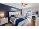 Comfortable bedroom with a sliding glass door to a patio, a fireplace, and a decorative wood-panel accent wall at 724 Barefoot Bay Loop, Groveland, FL 34736