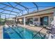 Screened-in pool area with in-pool seating, outdoor dining and living spaces and ceiling fan at 724 Barefoot Bay Loop, Groveland, FL 34736