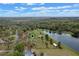 Aerial perspective featuring a home beside a lake and surrounded by woods with a green location pin dropped on top at 7729 Lake Andrea Cir, Mount Dora, FL 32757