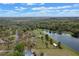 Aerial view of location near lake with ample yard and proximity to a verdant landscape at 7729 Lake Andrea Cir, Mount Dora, FL 32757