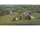 An aerial view showcases a home with a spacious, green lot, set alongside a lake, with numerous trees and outbuildings at 7729 Lake Andrea Cir, Mount Dora, FL 32757