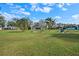 Large backyard featuring mature trees, play set, and furniture at 7729 Lake Andrea Cir, Mount Dora, FL 32757