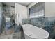 Bright bathroom featuring a freestanding tub, glass shower, and marble tile backsplash at 7729 Lake Andrea Cir, Mount Dora, FL 32757