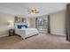 Large bedroom features a ceiling fan, neutral walls, and a window offering a pleasant view at 7729 Lake Andrea Cir, Mount Dora, FL 32757
