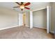 Carpeted bedroom features an open closet and neutral walls, creating a serene space at 7729 Lake Andrea Cir, Mount Dora, FL 32757