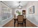 Stylish dining room with wood floors, wainscoting, modern light fixture, and bright, natural light at 7729 Lake Andrea Cir, Mount Dora, FL 32757