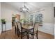 Formal dining room with wood floors, wainscoting, contemporary chandelier, and bright window at 7729 Lake Andrea Cir, Mount Dora, FL 32757