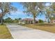 Home featuring a long driveway, mature trees, and well-maintained landscaping on a spacious lot at 7729 Lake Andrea Cir, Mount Dora, FL 32757