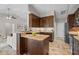 Well-lit kitchen featuring a granite countertop, stainless steel refrigerator, and wood cabinets at 7729 Lake Andrea Cir, Mount Dora, FL 32757