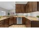 This kitchen features granite countertops, stainless steel dishwasher, and wood cabinets, creating a functional space at 7729 Lake Andrea Cir, Mount Dora, FL 32757