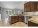 Bright kitchen showcasing a granite countertop, stainless steel dishwasher, and a view of the dining area at 7729 Lake Andrea Cir, Mount Dora, FL 32757