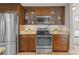 Modern kitchen with stainless steel appliances and wood cabinets, providing functionality and style at 7729 Lake Andrea Cir, Mount Dora, FL 32757