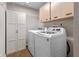 Functional laundry room features a washer, dryer, and ample storage cabinets at 7729 Lake Andrea Cir, Mount Dora, FL 32757