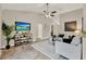 Cozy living room boasts a media center, plush rug, and a ceiling fan for added comfort at 7729 Lake Andrea Cir, Mount Dora, FL 32757