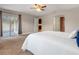 Bright main bedroom featuring a ceiling fan, neutral walls, and an open doorway at 7729 Lake Andrea Cir, Mount Dora, FL 32757