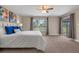 Bright main bedroom featuring a ceiling fan, neutral walls, and a view of the backyard at 7729 Lake Andrea Cir, Mount Dora, FL 32757