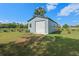 Exterior view of a single-door metal shed in the backyard with a tree in the background on a sunny day at 7729 Lake Andrea Cir, Mount Dora, FL 32757