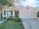 Charming single-story home with a well-manicured lawn, a bench, and an attached two-car garage at 9113 Sw 91St Court Rd, Ocala, FL 34481