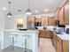 Stylish kitchen with bar seating, wooden cabinets, stainless steel appliances, and tiled flooring at 9113 Sw 91St Court Rd, Ocala, FL 34481