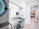 Well-lit laundry area with steel counter and sink, modern stacked washer and dryer, and white tiled backsplash at 9113 Sw 91St Court Rd, Ocala, FL 34481