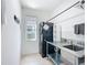 Clean laundry room featuring stainless steel counter, sink, mosaic tile backsplash, and modern washer and dryer at 9113 Sw 91St Court Rd, Ocala, FL 34481