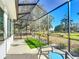Comfortable screened-in patio with an outdoor sitting area, synthetic turf, and views of the yard at 9113 Sw 91St Court Rd, Ocala, FL 34481