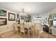 Bright dining room featuring a chandelier, hardwood floors and connection to living room with stone fireplace at 100 S Tremain St # G1, Mount Dora, FL 32757