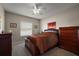 Bedroom with ceiling fan, window, and cherry wood furniture including queen sized bed at 10610 Masters Dr, Clermont, FL 34711