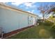 Side exterior view showing the home's siding, manicured lawn, and attached garage at 10610 Masters Dr, Clermont, FL 34711