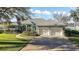 Lush landscaping compliments this beautiful home with a two car garage and lake view at 10610 Masters Dr, Clermont, FL 34711