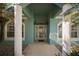 Inviting entryway with decorative glass door, columns, and lush landscaping around the home at 10610 Masters Dr, Clermont, FL 34711