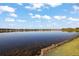 Beautiful lake view, reflecting the sky, with community homes on the opposite shore at 10610 Masters Dr, Clermont, FL 34711