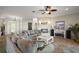 Cozy living room featuring a stone fireplace, ceiling fan, and comfortable sofas at 10610 Masters Dr, Clermont, FL 34711