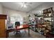 Home office featuring custom built-in shelving, a ceiling fan, and large windows at 10610 Masters Dr, Clermont, FL 34711